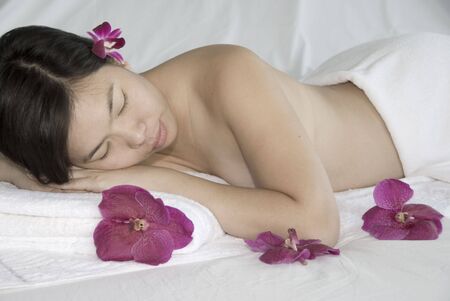beautiful young woman laying on massage table at spaの写真素材