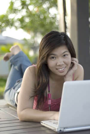 Asian female outdoors with her laptop computerの写真素材