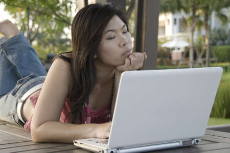 Asian female outdoors with her laptop computerの写真素材