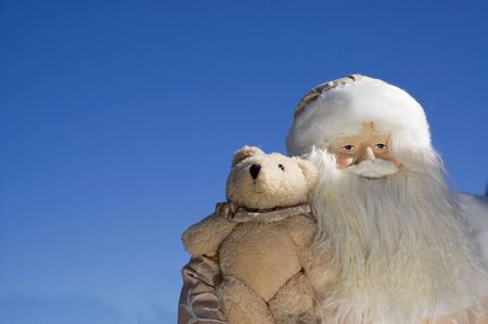 Santa Clause holding a teddy bearの写真素材