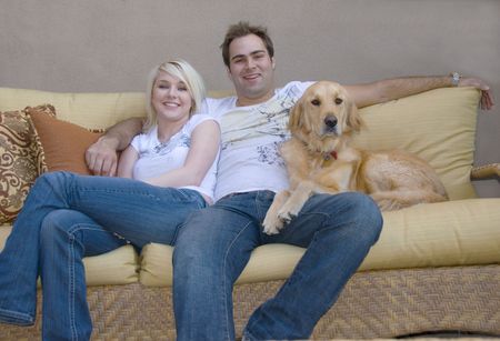 attractive modern young couple with their pet Golden Retrieverの写真素材