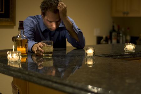 young man drinking and feeling despairの写真素材
