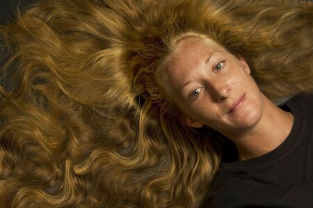 young woman with long hair laying downの写真素材