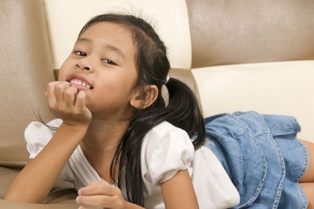 young Asian child laying down and looking at cameraの写真素材