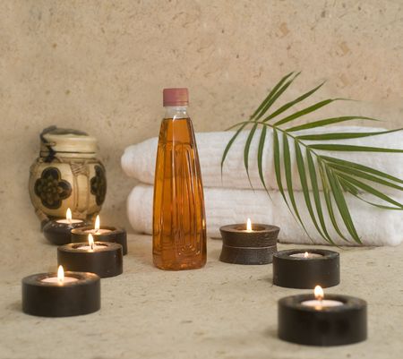 Massage oil and towels with candles at spa with room for textの写真素材