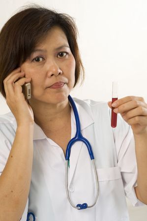 Asian woman working in a medical lab holding test tubeの写真素材