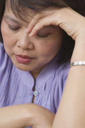 Woman holding her head and feeling depressedの写真素材