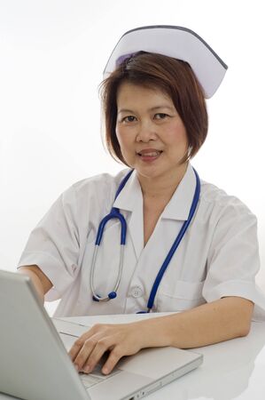 Attractive Asian medical professional sitting at desk with computerの写真素材