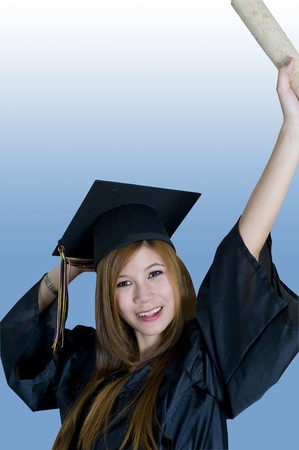 Young woman with graduation cap and gown holding diploma in the airの写真素材