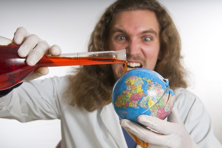 Mad Scientist pouring chemicals iover a globe の写真素材