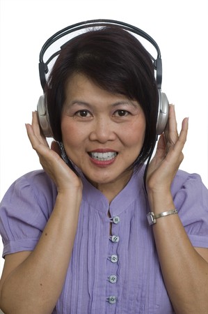 Middle aged Asian woman listening to music on headphonesの写真素材
