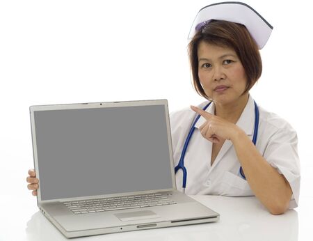 Attractive Asian medical professional pointing to blank screen on computerの写真素材