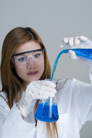Scientist pouring chemicals in a laboratoryの写真素材