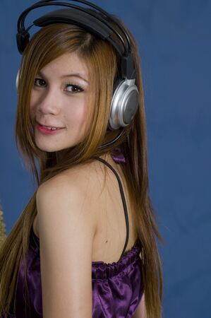 Sexy young girl listening to music on headphonesの写真素材