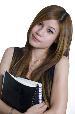 Young attractive female Asian student holding her school booksの写真素材