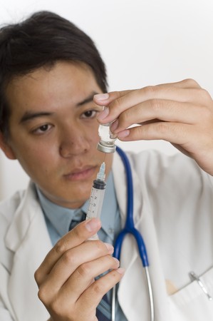 Doctor or Nurse standing with syringe filling with vaccineの写真素材