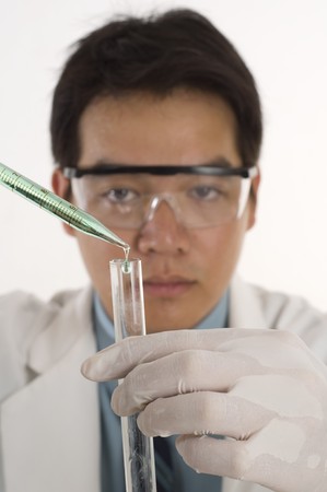 Scientist pouring chemicals in a laboratoryの写真素材