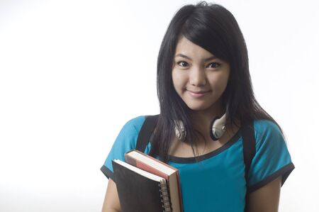 Young attractive female Asian student holding her school books
