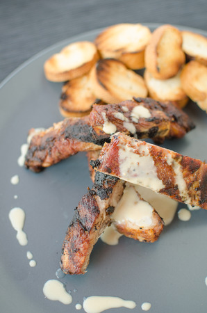 Spareribs on grill with dip, toasted baguetteの写真素材