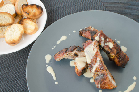 Spareribs on grill with dip, toasted baguetteの写真素材