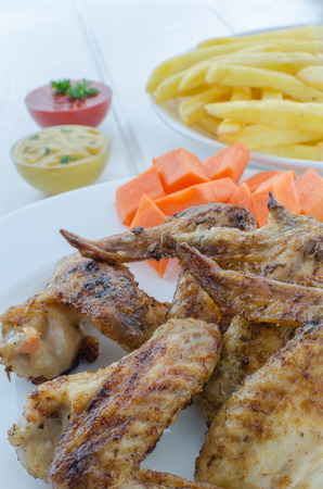Chicken wings with french fries,sauce and vegetables の写真素材