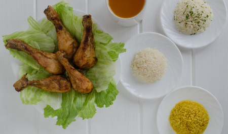 Grilled chicken thighs with with three rice on white woodの写真素材