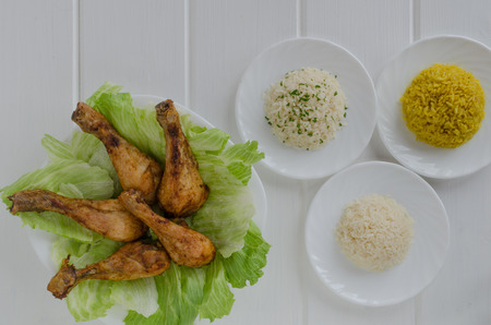 Grilled chicken thighs with with three rice on white woodの写真素材