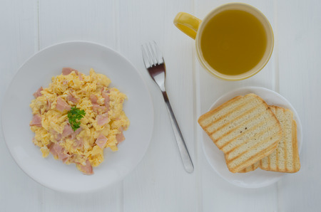 scrambled eggs with toast on white boardの写真素材