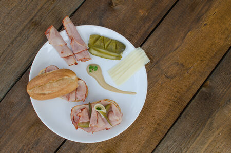 Open sandwich with cheese, baquette, ham and pickled cucumberの写真素材