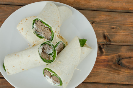Wrap with pork meal, creame and romaine lettuce on woodの写真素材