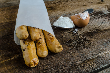 Homemade baked breadsticks on wood table with eggs