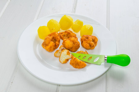 Fried cauliflower with nice green knife and potatoの写真素材
