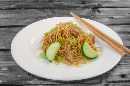 Chinese noodles with chicken on wood with chopsticksの写真素材