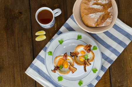 Muffins with eggs and bacon with black tea and lemonの写真素材