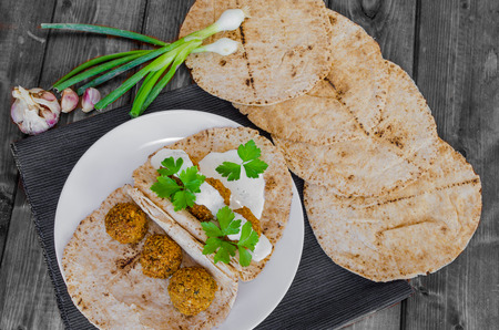 Chickpea falafel with mint dressing and Lebanese bread, fresh herbs on topの写真素材