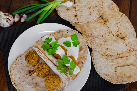 Chickpea falafel with mint dressing and Lebanese bread, fresh herbs on topの写真素材