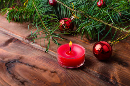 Christmas candle with pine needles on wood tableの写真素材
