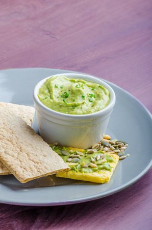 Avocado-Buttermilk Green Goddess Dip with fresh herbs and  Crispbread with a mixture of seedsの写真素材