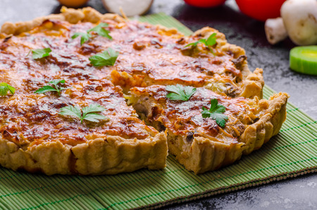 Home French cake stuffed with mushrooms, tomato and leek and ingredience togetherの写真素材