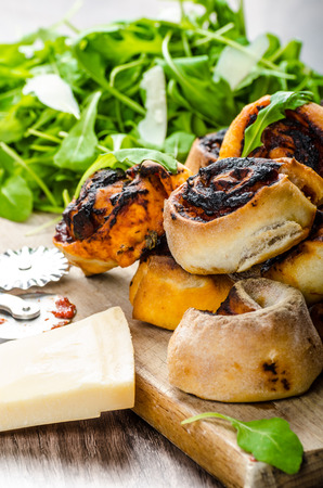 Pizza snails, minipizza with salad and parmagio on wood boardの写真素材