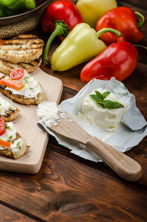 Healthy baguette, spread curd cheese with vegetable and herbs, variations of peppersの写真素材