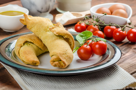 Home calzone rolls stuffed with cherry tomatoes, basil pesto and spinach with bio garlicの写真素材