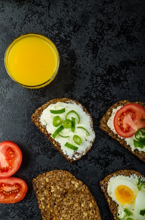 Healthy snack, whole wheat bread with cream cheese bio, tomato, spring onions and boiled eggの写真素材