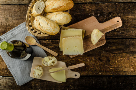 Delicious ripe cheese with crispy baguette and wine, wood board