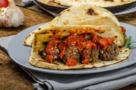 Indian naan with meatballs and tomato sauce, spicy sauce and exotic indian naan breadの写真素材