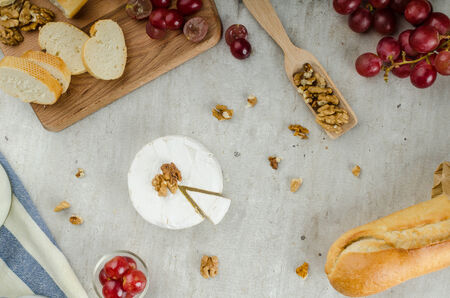 Fresh camembert from organic farms with red grapes and toasted baguetteの写真素材