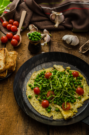 Healthy omelet with vegetables - peas and sunflower microgreens, cherry tomatoes toastの写真素材