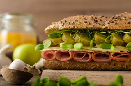 Baguette with the Prague ham, pickles, microgreens healthy herbs and emmental cheeseの写真素材