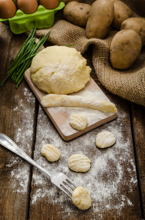 Preparing gnocchi, homemade with fork, all organic, cutting board and desk from woodの写真素材