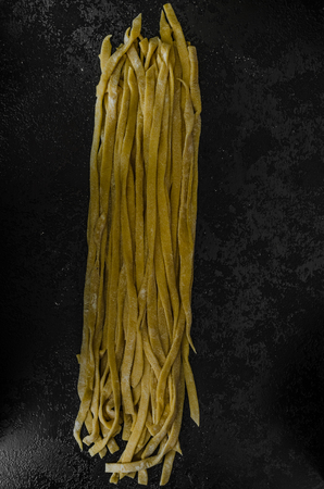 Homemade pasta, semolina flour, black backgroundの写真素材